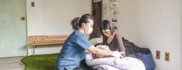 院長がお母さんに抱っこの仕方を教えている様子