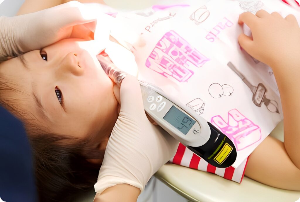 口の中に器具を入れて検査を受ける子ども